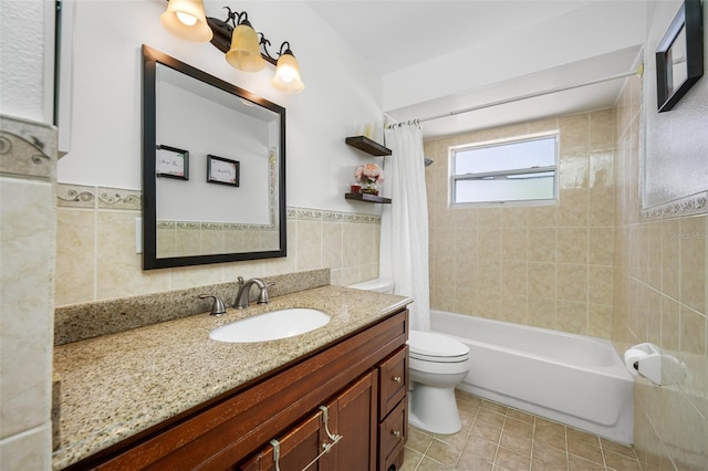 full bathroom with tile patterned floors, vanity, shower / tub combo with curtain, tile walls, and toilet