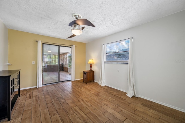 interior space featuring hardwood / wood-style floors, ceiling fan, a healthy amount of sunlight, and a textured ceiling