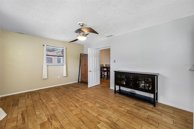 unfurnished bedroom with a textured ceiling, light wood-type flooring, and ceiling fan