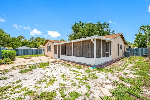 back of house with a sunroom, a patio area, and central AC