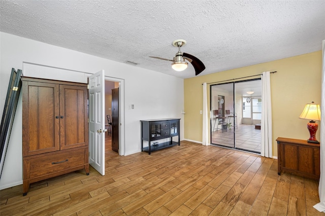 unfurnished living room featuring a textured ceiling, light hardwood / wood-style flooring, and ceiling fan