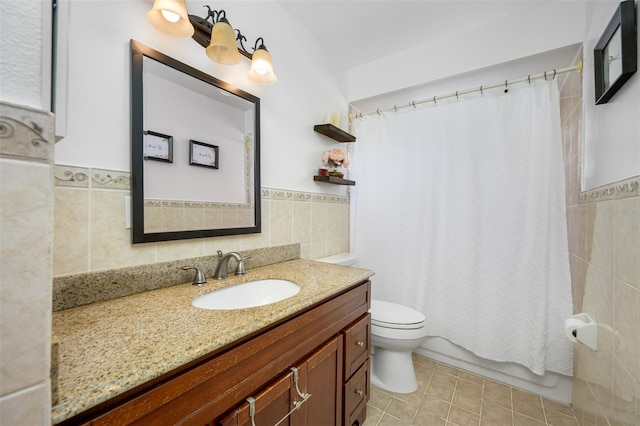 bathroom featuring toilet, vanity, tile patterned floors, and tile walls