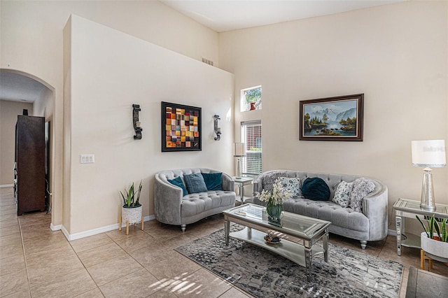 living room featuring a towering ceiling and light tile patterned floors