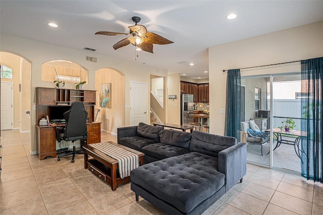 tiled living room with plenty of natural light and ceiling fan