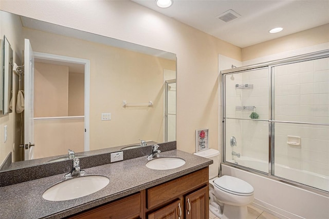 full bathroom featuring tile patterned flooring, vanity, toilet, and shower / bath combination with glass door