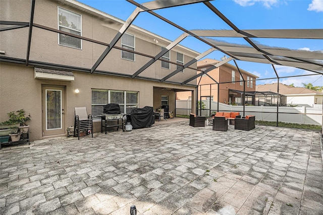 view of patio featuring outdoor lounge area and glass enclosure