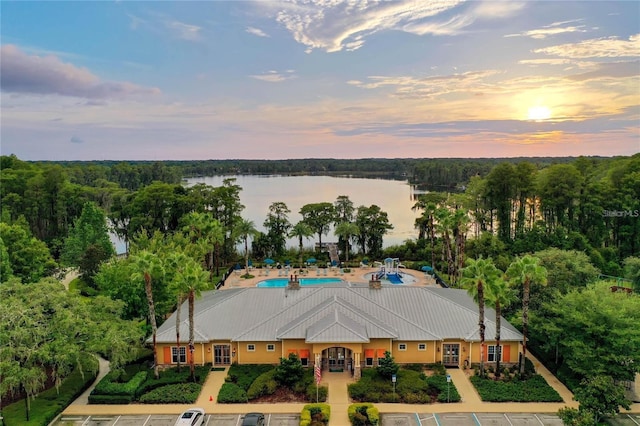 aerial view at dusk featuring a water view