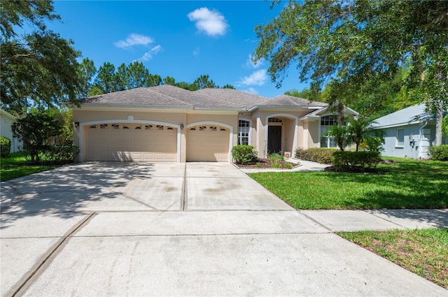 ranch-style home with driveway, stucco siding, a front yard, and an attached garage