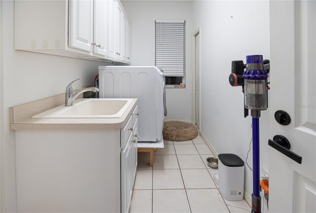 washroom with sink, washer / dryer, light tile patterned floors, and cabinets