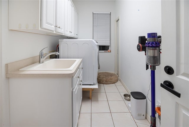 laundry area with light tile patterned flooring, baseboards, washer / clothes dryer, a sink, and cabinet space