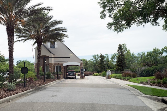 view of street featuring sidewalks, a gated entry, and curbs
