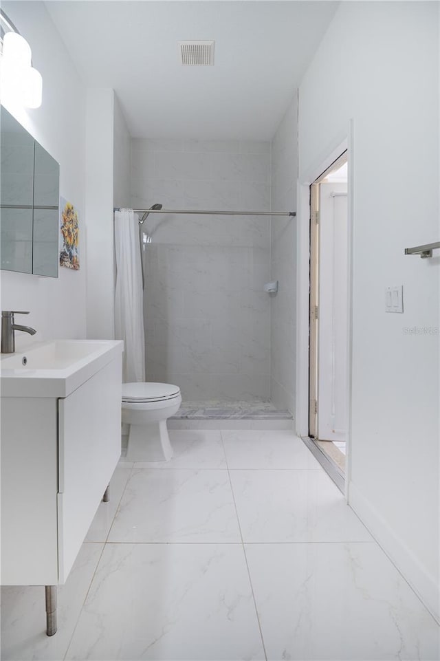 bathroom featuring visible vents, marble finish floor, a tile shower, toilet, and vanity