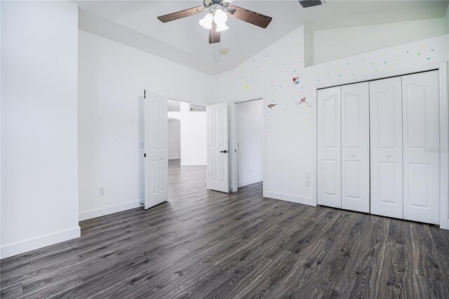 unfurnished bedroom with ceiling fan, high vaulted ceiling, a closet, and dark hardwood / wood-style floors