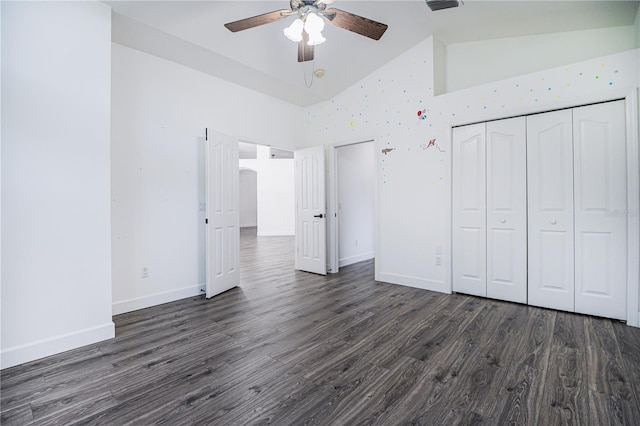 unfurnished bedroom featuring baseboards, dark wood-style flooring, high vaulted ceiling, and a closet