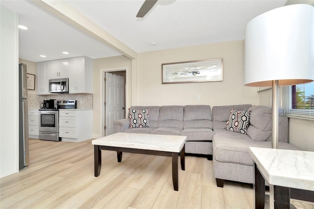 living room with ceiling fan and light wood-type flooring