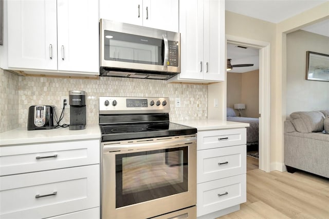 kitchen featuring white cabinets, appliances with stainless steel finishes, light wood-type flooring, and ceiling fan