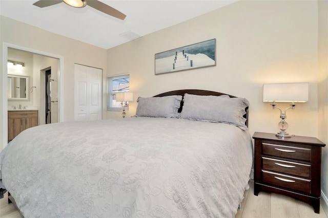 bedroom featuring ensuite bathroom, ceiling fan, sink, light hardwood / wood-style floors, and a closet