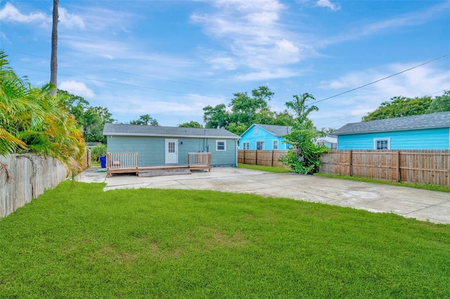 back of property featuring a yard and a wooden deck