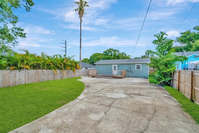 rear view of house with a lawn and a deck