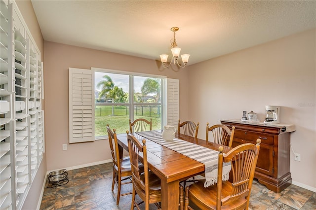 dining area featuring a textured ceiling and a notable chandelier