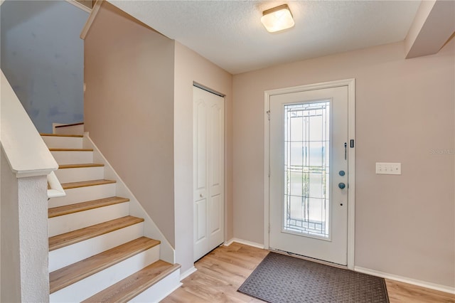 foyer featuring a textured ceiling and light wood-type flooring