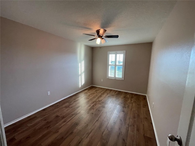 empty room with ceiling fan, dark hardwood / wood-style flooring, and a textured ceiling