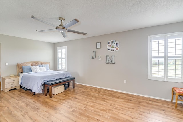 228 Star Shell Dr, Apollo Beach, FL 33572 - bedroom featuring light wood-style flooring, a textured ceiling, baseboards, and ceiling fan