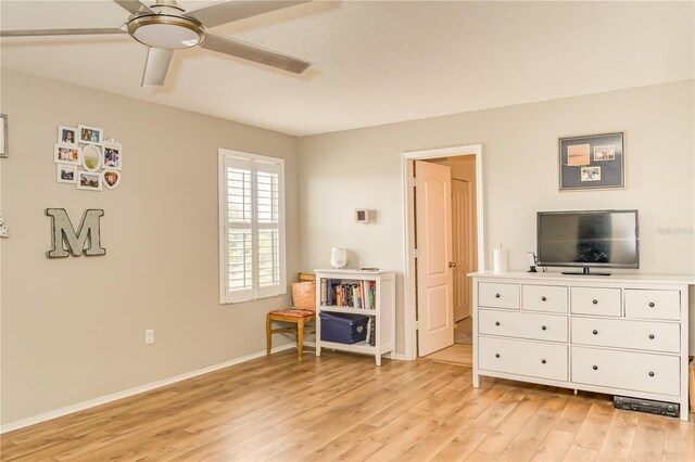 bedroom featuring a ceiling fan, baseboards, and light wood-style floors