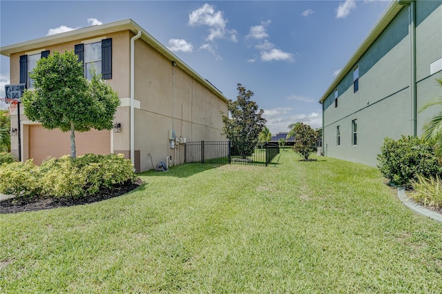 view of yard featuring fence and a garage