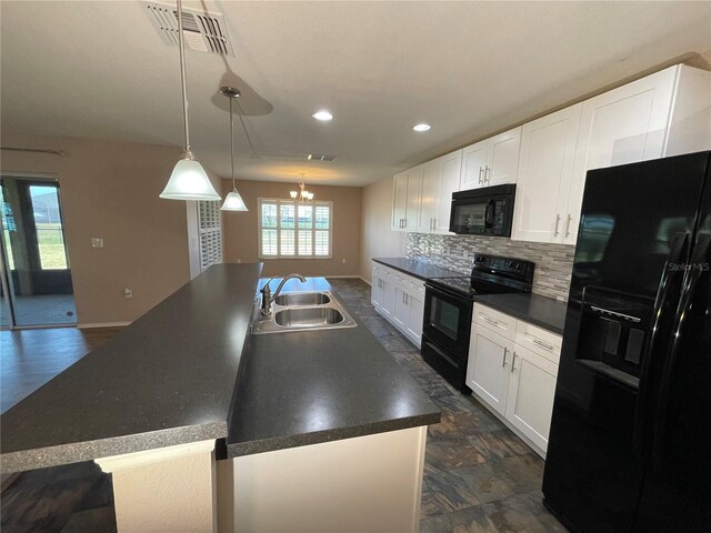 kitchen with black appliances, dark countertops, a sink, visible vents, and a center island with sink