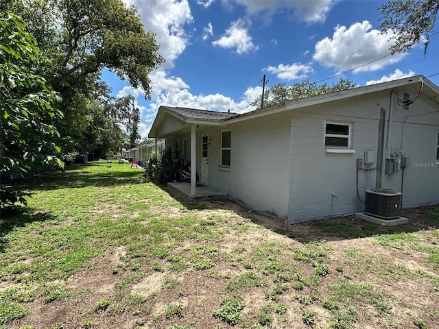 view of home's exterior featuring central air condition unit and a lawn