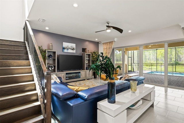 living room with a fireplace and ceiling fan