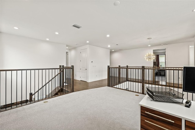 carpeted empty room with a notable chandelier