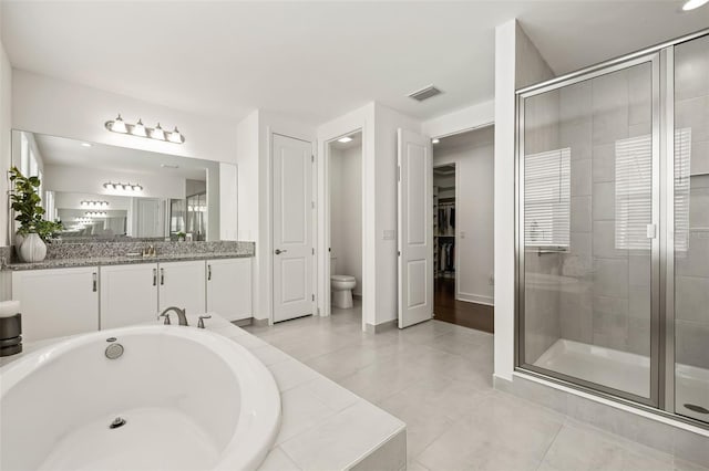 full bathroom with toilet, vanity, tile patterned floors, and independent shower and bath