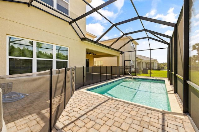 view of swimming pool featuring a patio, glass enclosure, and ceiling fan