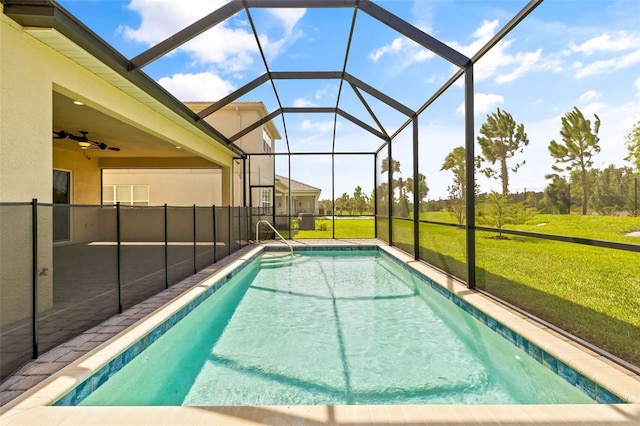 view of swimming pool with a lanai, a patio area, ceiling fan, and a yard