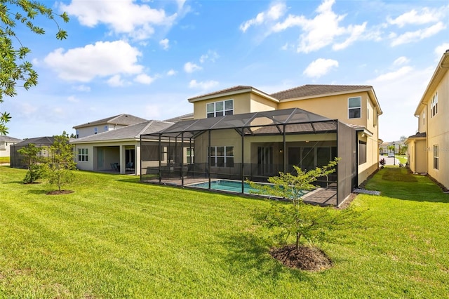 rear view of house with a lanai and a yard