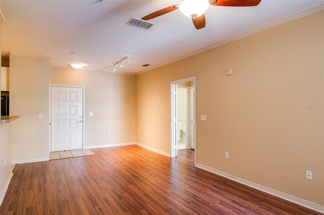 unfurnished room with baseboards, crown molding, visible vents, and dark wood-type flooring