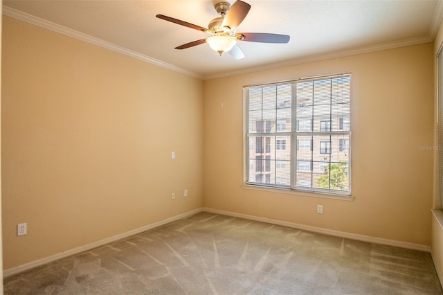 spare room with carpet flooring, crown molding, baseboards, and ceiling fan