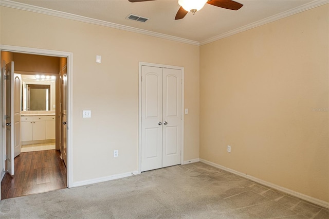 unfurnished bedroom with carpet floors, ornamental molding, visible vents, and baseboards