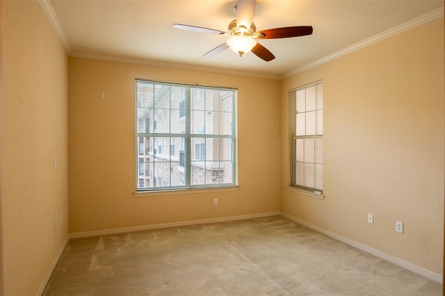 unfurnished room with a ceiling fan, light colored carpet, crown molding, and baseboards