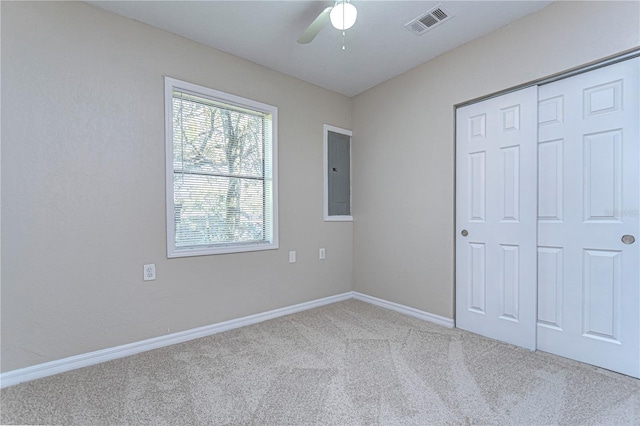 unfurnished bedroom featuring ceiling fan, light colored carpet, and a closet