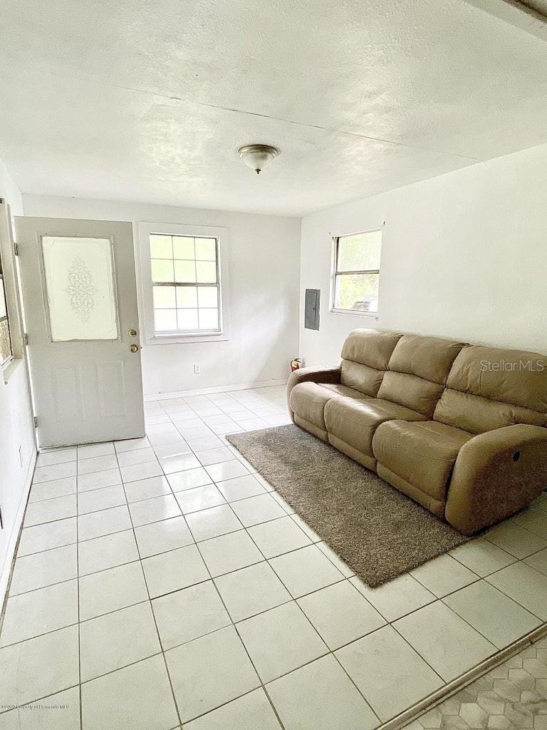 tiled living room featuring a textured ceiling