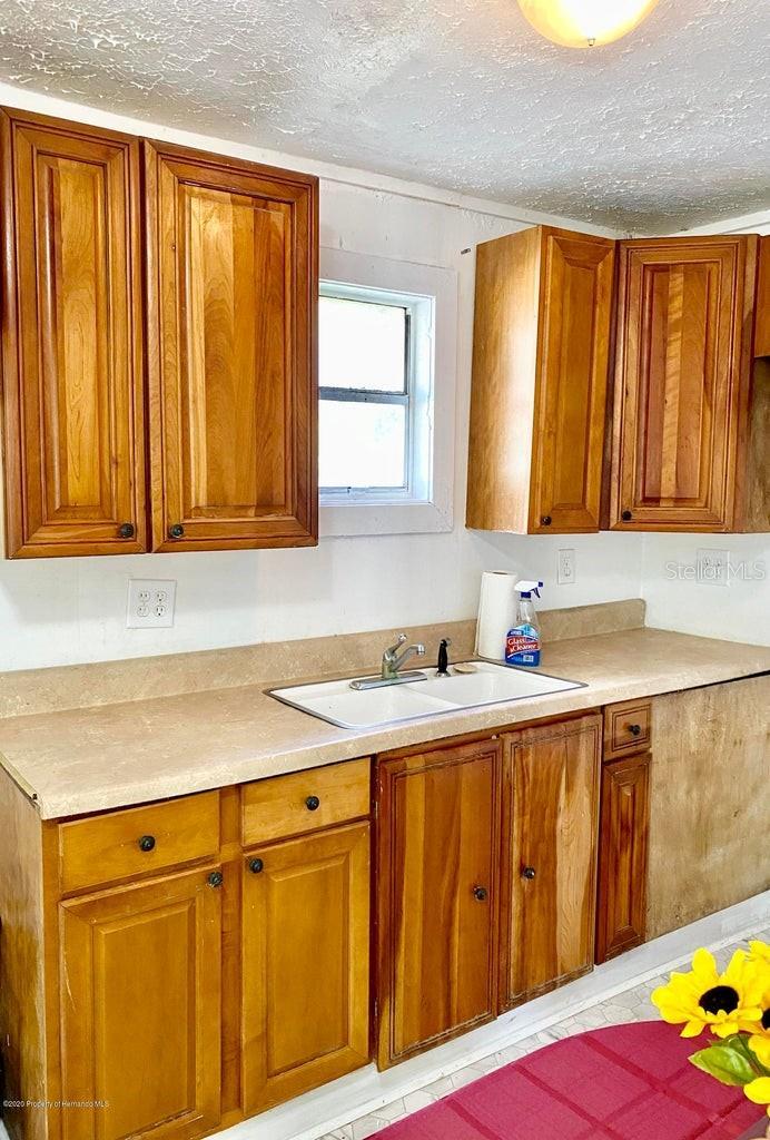 kitchen with light tile patterned floors, a textured ceiling, and sink