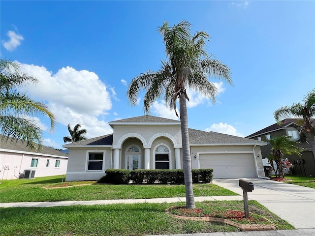 view of front of property with cooling unit, a front lawn, and a garage