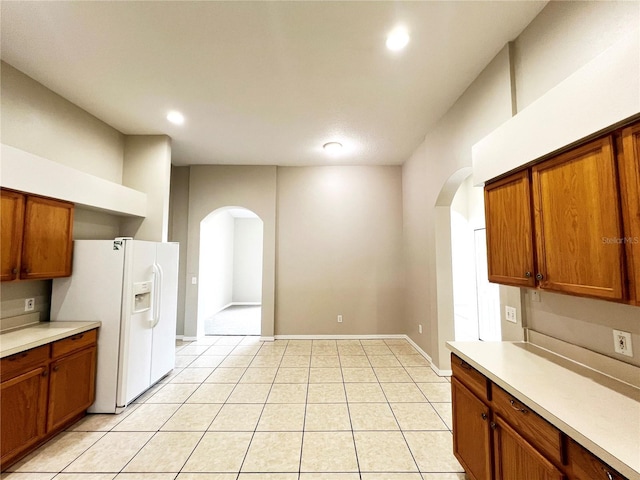 kitchen featuring white fridge with ice dispenser and light tile patterned flooring