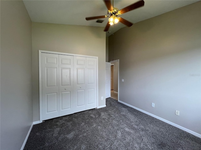 unfurnished bedroom featuring ceiling fan, a closet, lofted ceiling, and dark colored carpet