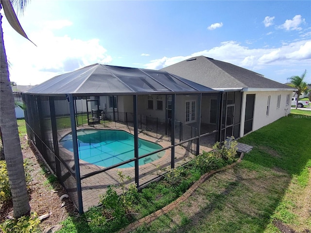 view of pool with a yard, a patio, and glass enclosure