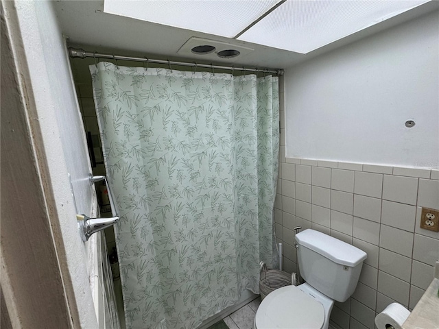 bathroom with a shower with shower curtain and toilet