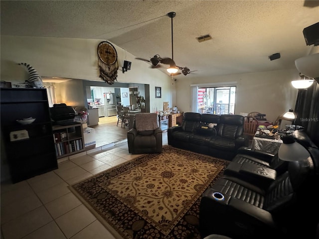 tiled living room featuring ceiling fan, lofted ceiling, and a textured ceiling